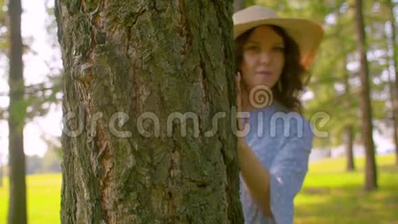 站在树旁的年轻漂亮的女人视频的预览图