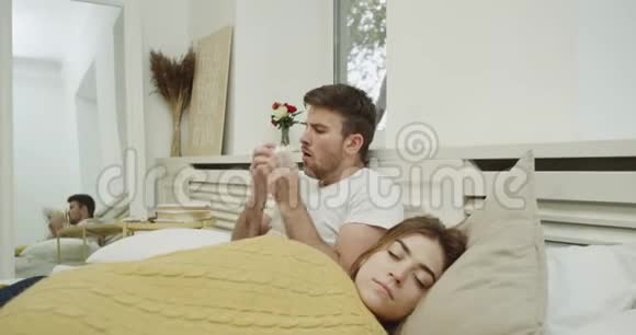 流感时间对于一个年轻人来说非常糟糕他和他的女人上床流鼻涕女人睡觉视频的预览图