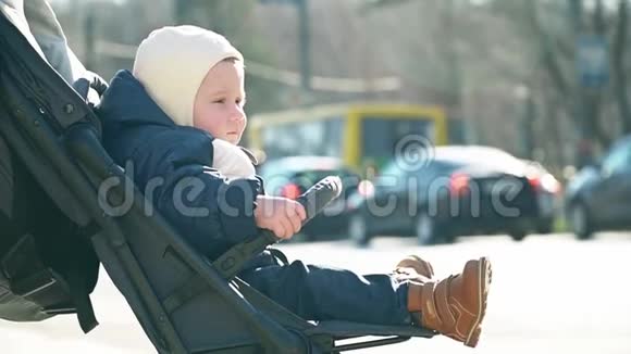 小男孩坐在婴儿车里车上有车视频的预览图