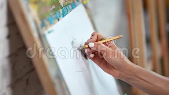 熟练女画家用铅笔在白纸画布上绘制手绘素描视频的预览图