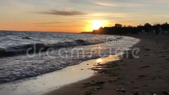 芬兰湾海岸日落沙滩上的金色海浪视频的预览图