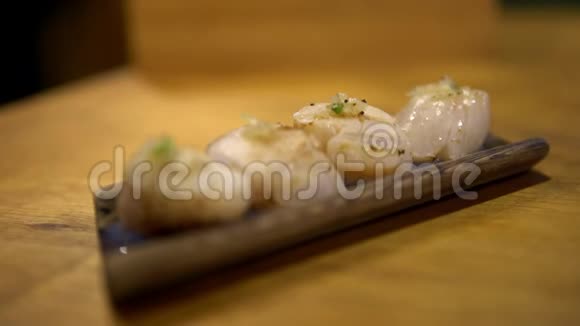4K吃日本木碟上的扇贝生鱼片或热生鱼片视频的预览图