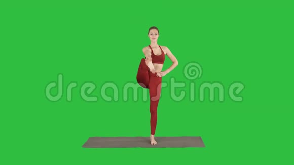 女性瑜伽模型使站立分裂微笑在绿色屏幕铬键视频的预览图