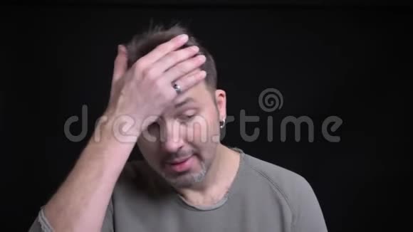 中年白种人的肖像用耳环打手势在黑色镜头上显示烦恼视频的预览图