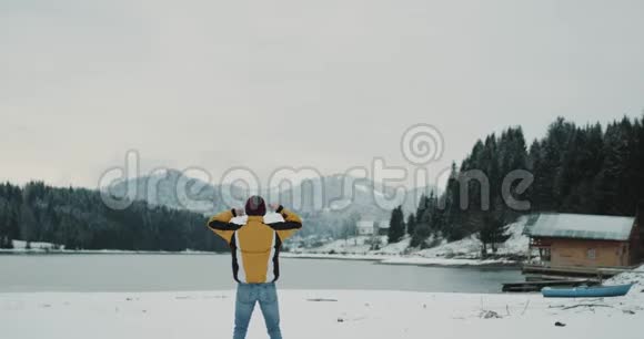 美丽的大自然在山林和雪湖中间一个快乐的游客欣赏着这里的风景视频的预览图