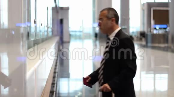 旅客商务人员在机场办理登机手续领取机票视频的预览图