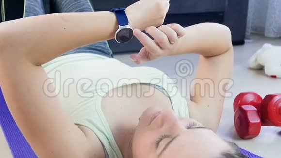 年轻女子在做运动前手腕上使用健身追踪器的慢动作镜头视频的预览图