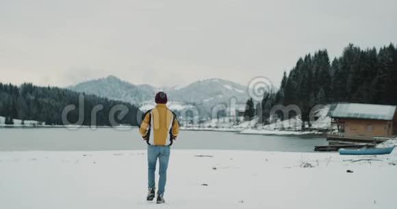 欢乐的游客在湖和山的中央欣赏大自然的美丽在冬天的景色旁边令人惊叹视频的预览图