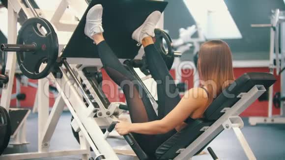 一位在健身房锻炼的运动员在训练器械上进行腿部按压视频的预览图