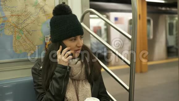 年轻女子在纽约地铁列车上打电话视频的预览图