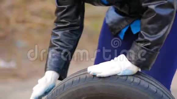 女人手在沥青车轮胎上用圆盘滚动视频的预览图