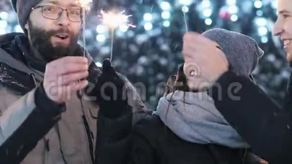 在户外庆祝新年的朋友们的特写镜头在背景的模糊中保留闪烁的灯光视频的预览图