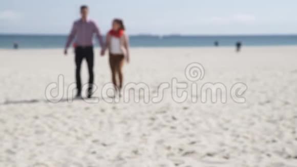一对情侣在阳光明媚的寒冷日子在沙滩上散步视频的预览图