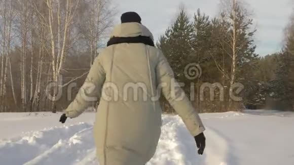 幸福的女孩走在雪林在霜冻的一天后景冬季活动视频的预览图