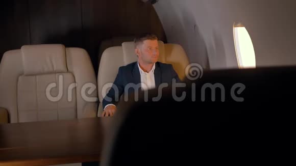 坐在舒适的商务飞机扶手椅上的商人画像视频的预览图