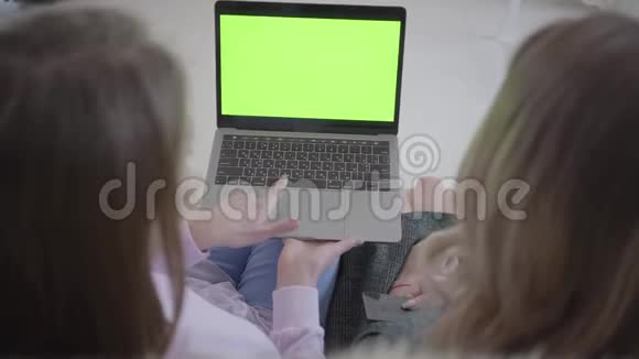 两个女孩背对着镜头坐着女人讨论屏幕上显示的是什么一个给另一个信用卡视频的预览图