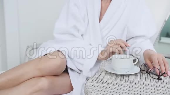 一位中年妇女躺在露台上的阳光休息室里洗了个热水澡后在新鲜空气中休息视频的预览图