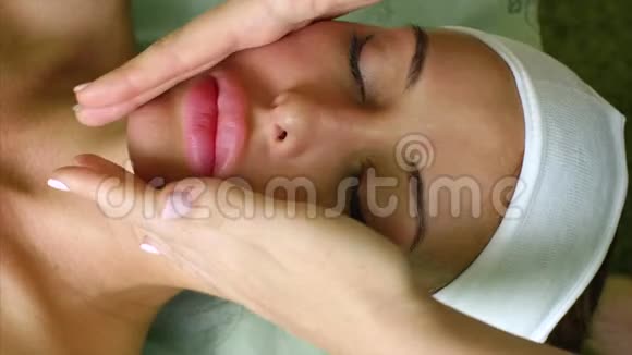 按摩治疗师美容师为美容院的妇女做脸颊按摩视频的预览图
