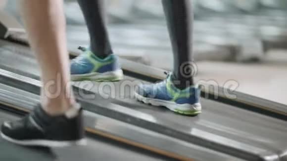 在健身健身房的跑步机上特写两双脚视频的预览图