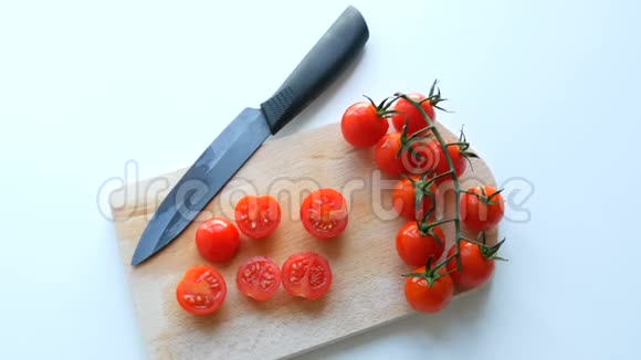 时尚的陶瓷菜刀和成熟的红色小樱桃番茄成串部分切在视频的预览图