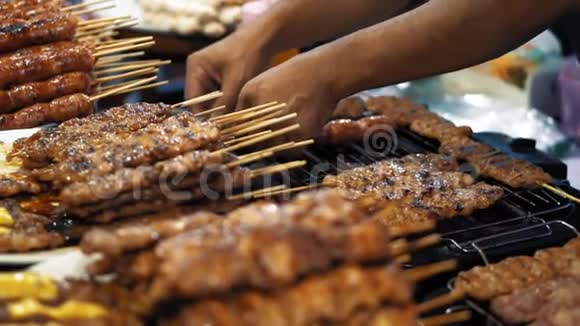 厨师把美味的鸡肉和猪肉串烧在热烤架上慢动作带肉和香肠烧烤的大盘子视频的预览图