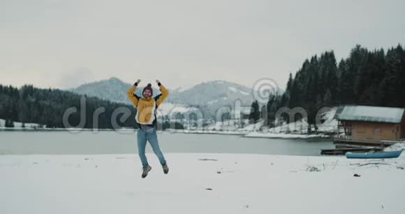 快乐的一天一位游客来到了一个美丽的风景之地有着雪山和雪湖游客在四周跳跃视频的预览图
