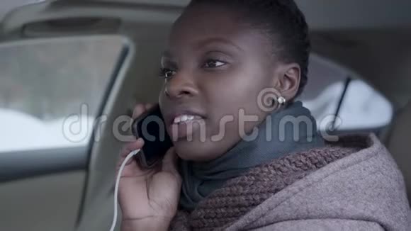 自信的非洲裔美国妇女坐在车里用手机近距离交谈的肖像美丽的女人视频的预览图