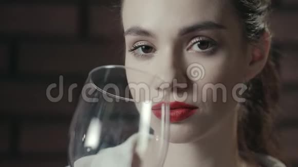 有魅力的女人从杯子里喝红葡萄酒喝红酒的女士视频的预览图