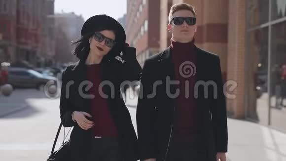 一对时髦的夫妇手牵手走在城市大街上视频的预览图