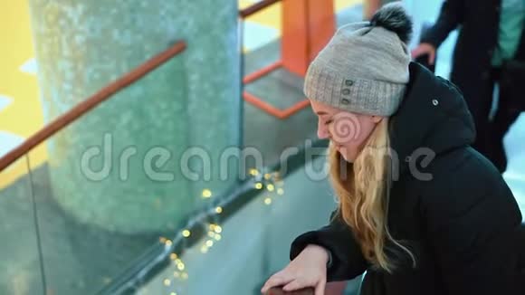 年轻漂亮的女孩在商场里坐自动扶梯向上视频的预览图