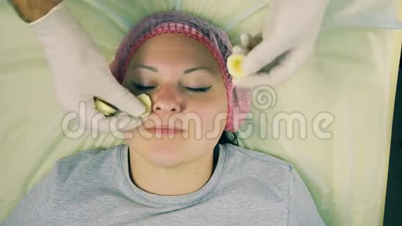一个戴手套的男性美容师的手把香蕉面具戴在女人脸上视频的预览图