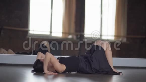 穿着黑色衣服的时髦女人在慢动作的镜子附近做瑜伽体式桥视频的预览图