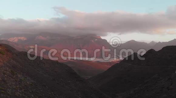 无人机在群山之间飞行日落在一个沙漠山谷蛇形没有汽车西班牙大加那利视频的预览图
