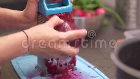 女家庭主妇用甜菜根在钢烤架上摩擦视频的预览图
