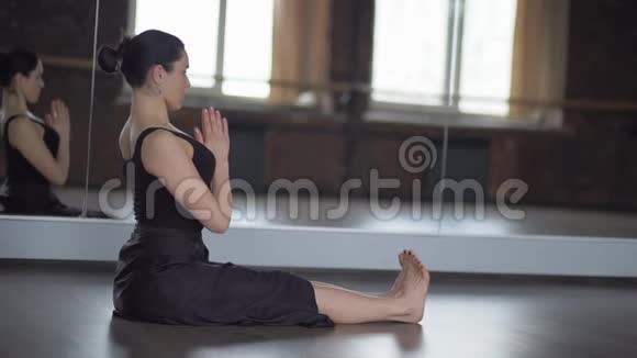 穿着黑色衣服的时髦女人会在瑜伽中缓慢地运动视频的预览图