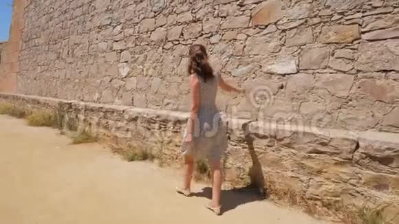 女子触摸石墙欣赏城堡观光视频的预览图
