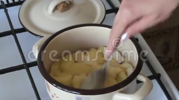 一个女人正在把苹果切成薄片苹果在平底锅里煮得到苹果酱视频的预览图