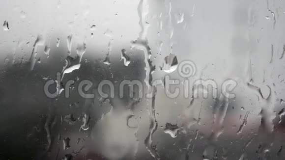 强雨水冲向窗玻璃并流下来关闭雨天玻璃背景上的雨滴视频的预览图