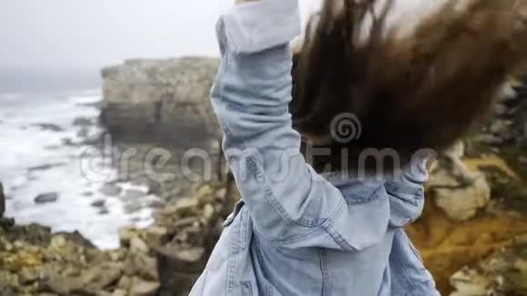 岩石海岸上快乐的女人视频的预览图