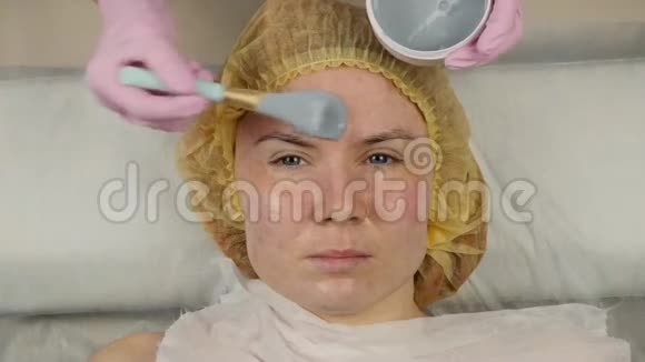 美容师在水疗沙龙为女性脸涂抹泥面膜面部年轻化程序水疗4K视频的预览图