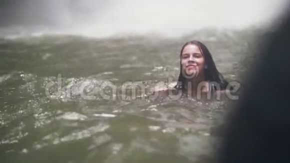 美丽的女人在山湖里游泳水溅在背景上旅游妇女在淡水中洗澡视频的预览图