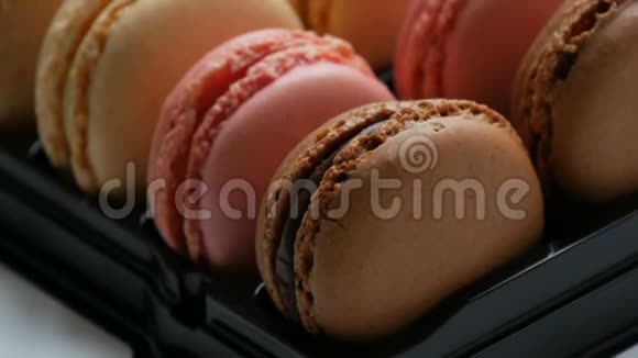 五颜六色的法国饼干通心粉在一个特殊的黑色盒子上的白色桌子礼品盒中的彩色蛋糕Macaroon视频的预览图