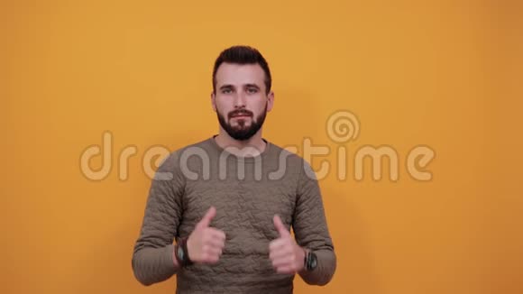 一个没有胡子的英俊男人看着摄像机竖起大拇指视频的预览图