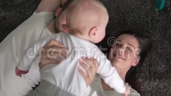 年轻可爱开朗的家庭正在地板上玩耍妈妈爸爸和小可爱的儿子在中间视频的预览图