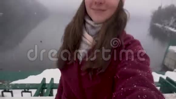 快乐的女人出现在阿布哈兹的里萨湖冬天的雪天视频的预览图