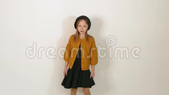 一个穿着黑帽子黑衣服和棕色夹克的小女孩在工作室的肖像视频的预览图
