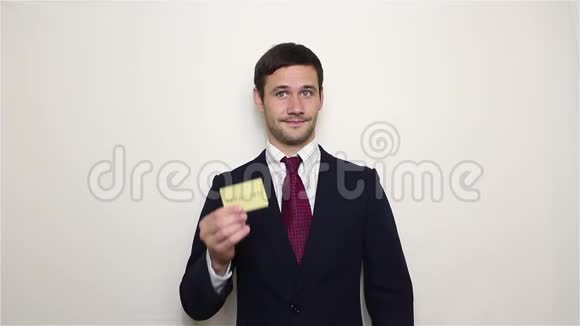 年轻英俊的商人展示了他的黄金信用卡并摩擦他的手指显示一个利润标志视频的预览图