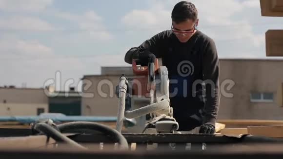 工业青年木工使用木切割机人切木木板视频的预览图