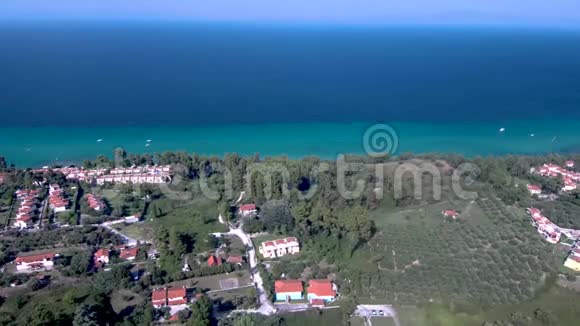 鸟瞰绿松石和蓝色海岸和游客之家在克里奥皮吉哈尔基迪基希腊侧面移动无人机视频的预览图