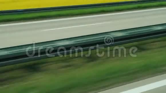 沿着高速公路在绿油油的田野间快速行驶视频的预览图